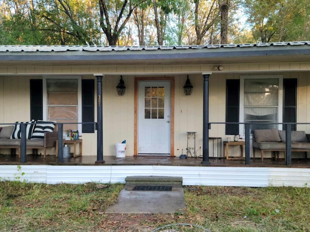 property entrance with a porch and metal roof