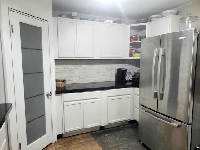 kitchen with freestanding refrigerator, open shelves, backsplash, and white cabinets
