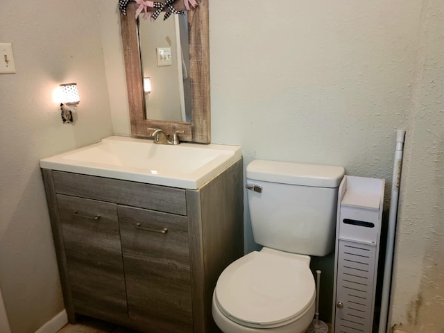 half bathroom with toilet and vanity