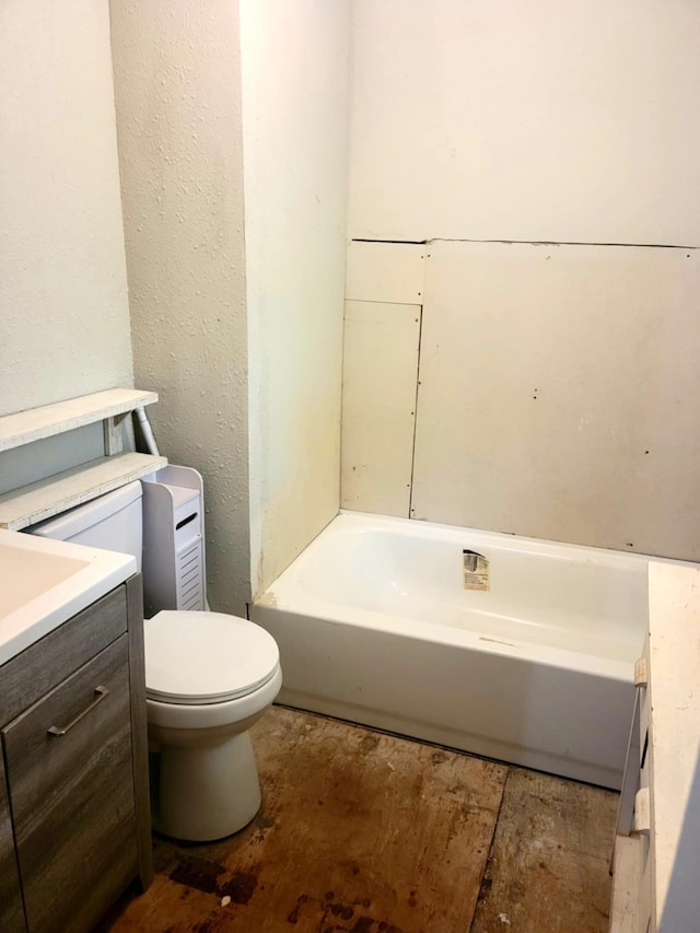 bathroom featuring toilet, a tub, and vanity