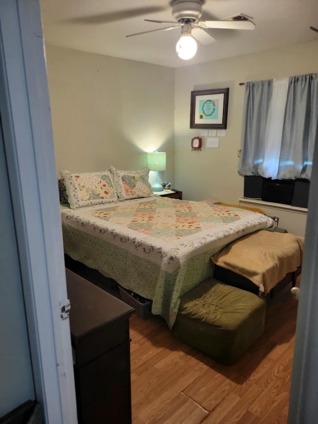 bedroom with a ceiling fan and light wood-type flooring