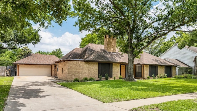 view of front facade featuring brick siding, a garage, a front yard, a chimney, and concrete driveway