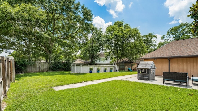 view of yard featuring a fenced in pool, a fenced backyard, and a patio area