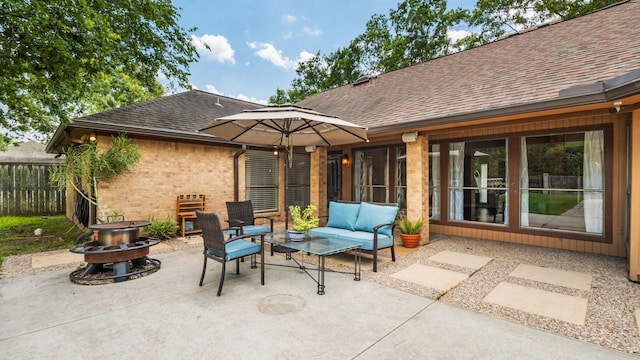 view of patio / terrace featuring fence and an outdoor living space with a fire pit