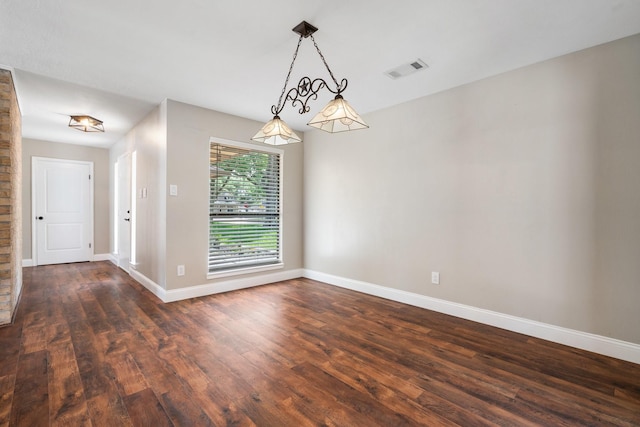 empty room with baseboards, visible vents, and dark wood-type flooring