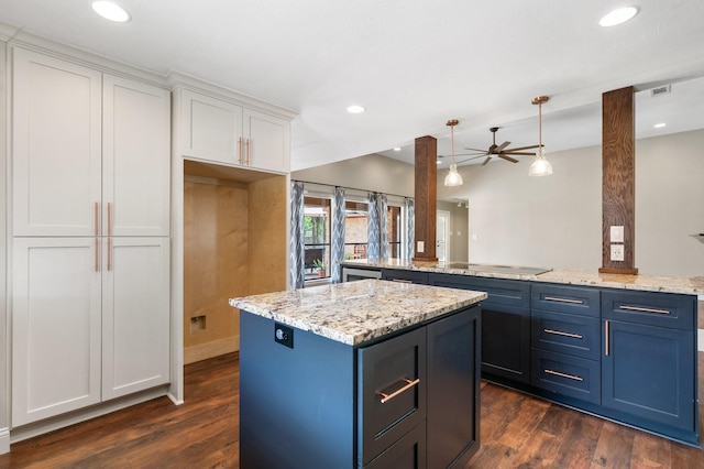 kitchen featuring white cabinets, a ceiling fan, a kitchen island, and dark wood-type flooring