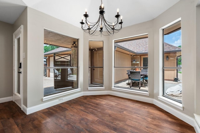 unfurnished dining area featuring wood finished floors, a chandelier, and a wealth of natural light