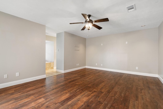spare room featuring baseboards, a ceiling fan, wood finished floors, and visible vents