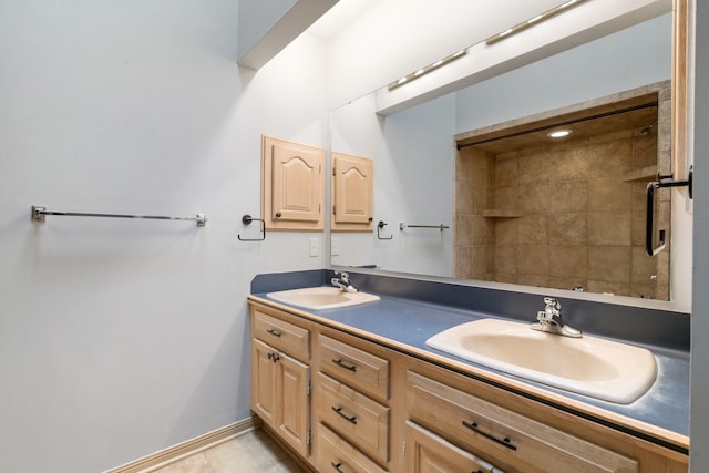 bathroom featuring a sink, baseboards, a shower, and double vanity