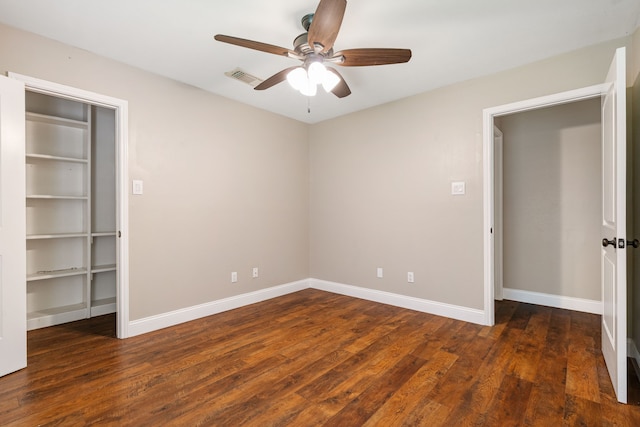 unfurnished bedroom with baseboards, a ceiling fan, wood finished floors, and visible vents