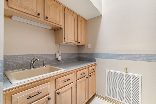 laundry room featuring light tile patterned floors, visible vents, and a sink