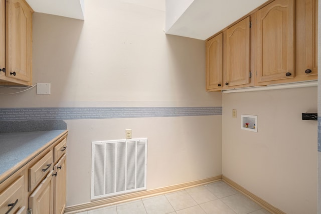 clothes washing area featuring visible vents, baseboards, hookup for a washing machine, cabinet space, and light tile patterned floors
