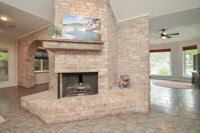 unfurnished living room with a textured ceiling, a ceiling fan, a fireplace, and baseboards