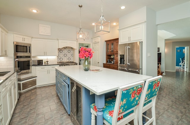 kitchen featuring appliances with stainless steel finishes, decorative backsplash, white cabinetry, and recessed lighting