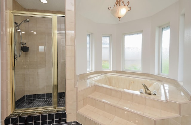 bathroom with a shower stall and a bath