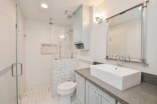 bathroom featuring a stall shower, toilet, and vanity