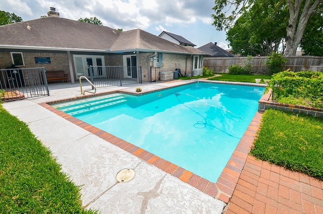view of swimming pool featuring french doors and a patio area