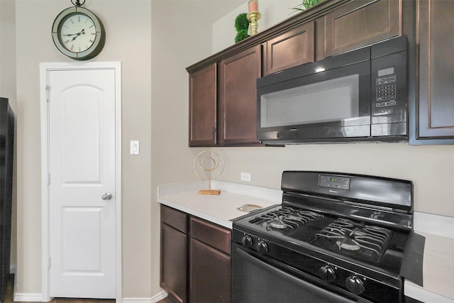 2415 Allendale Garden Ln, Spring, TX 77373 - kitchen featuring black appliances, light countertops, dark brown cabinetry, and baseboards