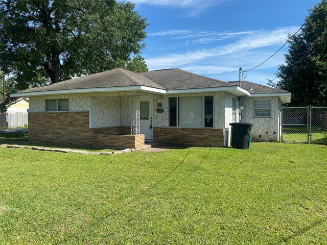 8038 Woodlyn Rd, Houston, TX 77028 - bungalow-style house featuring brick siding, a front lawn, roof with shingles, and fence