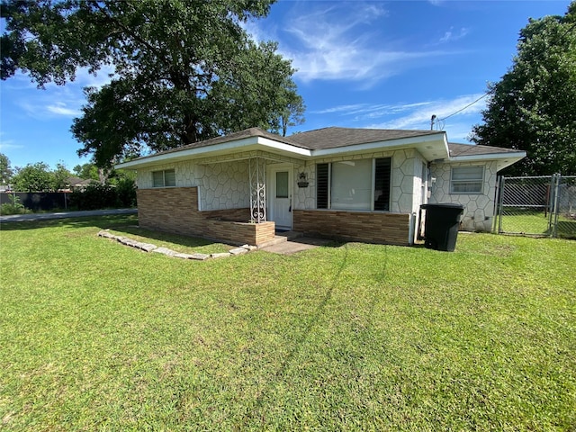 8038 Woodlyn Rd, Houston, TX 77028 - view of front of house with a front lawn, fence, stone siding, brick siding, and a gate