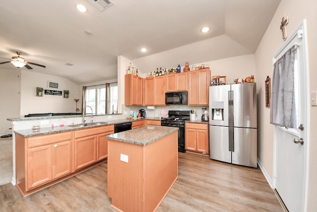 kitchen with a sink, light brown cabinets, a peninsula, lofted ceiling, and black appliances