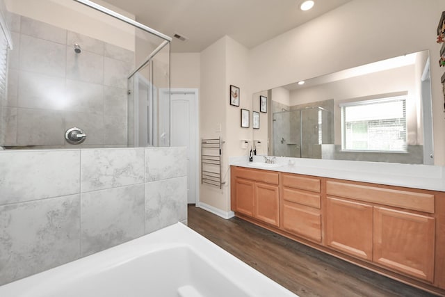 bathroom with visible vents, vanity, wood finished floors, recessed lighting, and a stall shower