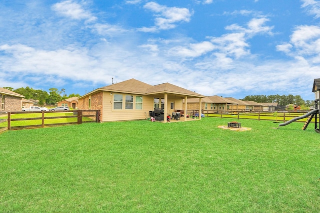 217 Kickapoo Dr, Anahuac, TX 77514 - back of house featuring an outdoor fire pit, a yard, a patio area, and a fenced backyard