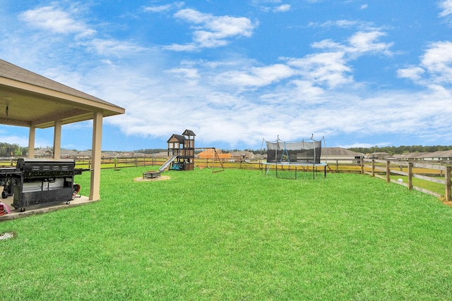 217 Kickapoo Dr, Anahuac, TX 77514 - view of yard with a fenced backyard, a playground, and a trampoline