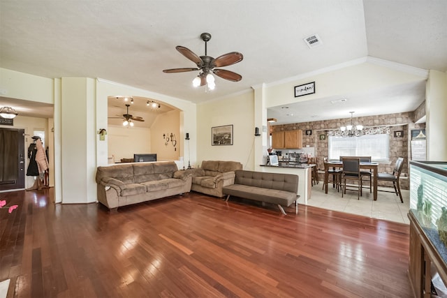 20319 Concord Hill Dr, Cypress, TX 77433 - living room featuring visible vents, arched walkways, light wood-style flooring, ceiling fan with notable chandelier, and vaulted ceiling