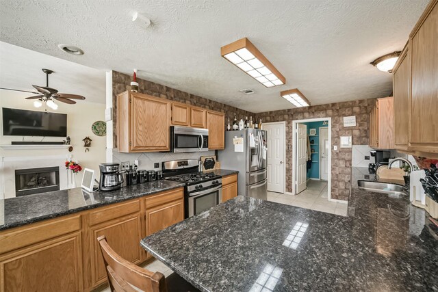 20319 Concord Hill Dr, Cypress, TX 77433 - kitchen with a peninsula, ceiling fan, a sink, appliances with stainless steel finishes, and light tile patterned floors