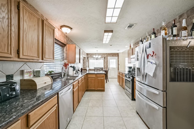 20319 Concord Hill Dr, Cypress, TX 77433 - kitchen featuring a textured ceiling, visible vents, a sink, a peninsula, and stainless steel appliances