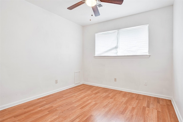 spare room with baseboards, ceiling fan, wood finished floors, and visible vents