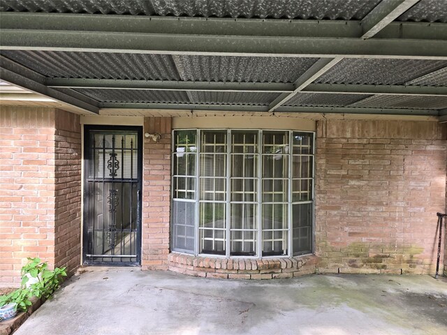 doorway to property with brick siding