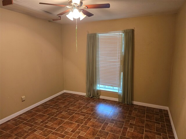 empty room with baseboards and a ceiling fan