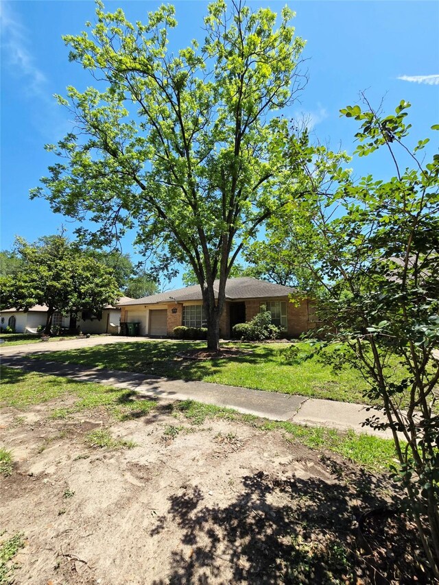 single story home with a garage, dirt driveway, and brick siding