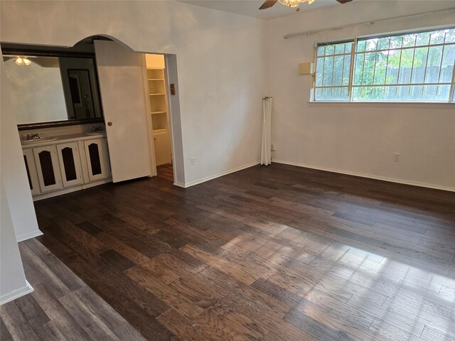 empty room with ceiling fan, dark wood-style floors, and baseboards
