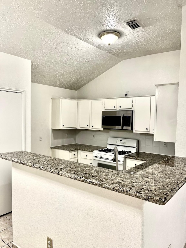 kitchen with white cabinets, a textured ceiling, stainless steel microwave, visible vents, and white range with gas cooktop