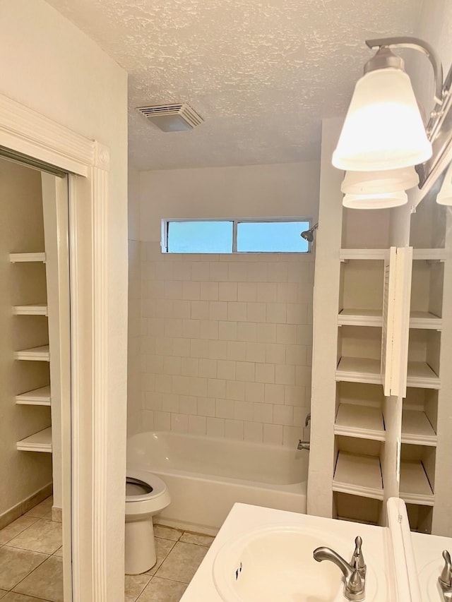 bathroom featuring visible vents, tile patterned flooring, toilet, a textured ceiling, and a sink