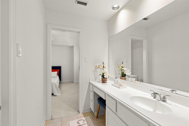 bathroom featuring vanity, baseboards, visible vents, and tile patterned floors