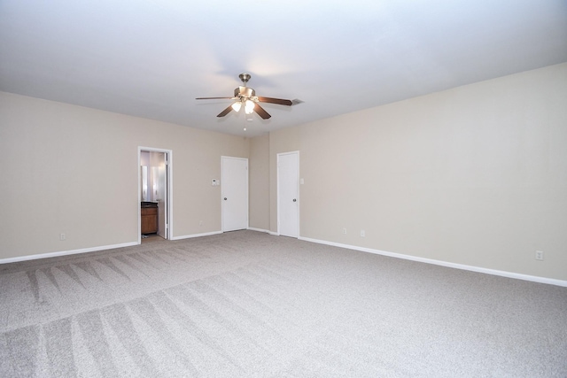 spare room featuring baseboards, ceiling fan, and carpet flooring