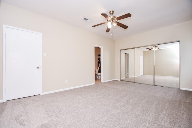 unfurnished bedroom with carpet, a ceiling fan, baseboards, ensuite bathroom, and visible vents
