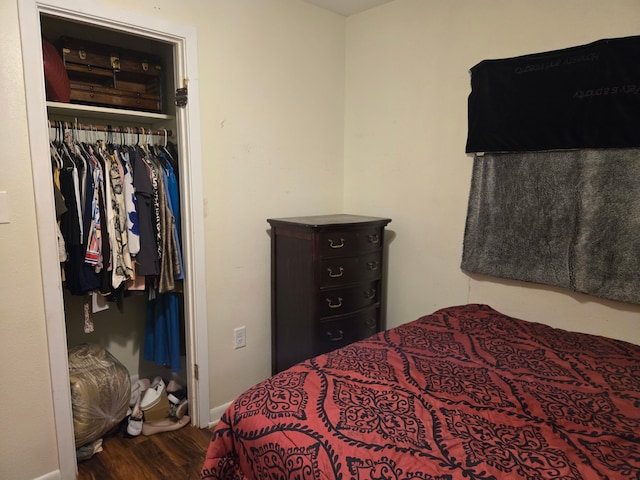 bedroom featuring baseboards, wood finished floors, and a closet
