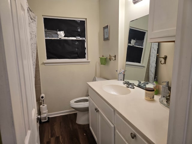 bathroom with vanity, baseboards, wood finished floors, and toilet