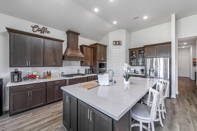 41015 Kimber Ln, Magnolia, TX 77354 - kitchen featuring visible vents, a spacious island, light countertops, custom range hood, and stainless steel appliances