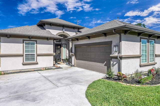 41015 Kimber Ln, Magnolia, TX 77354 - prairie-style house with stucco siding, driveway, roof with shingles, and a garage
