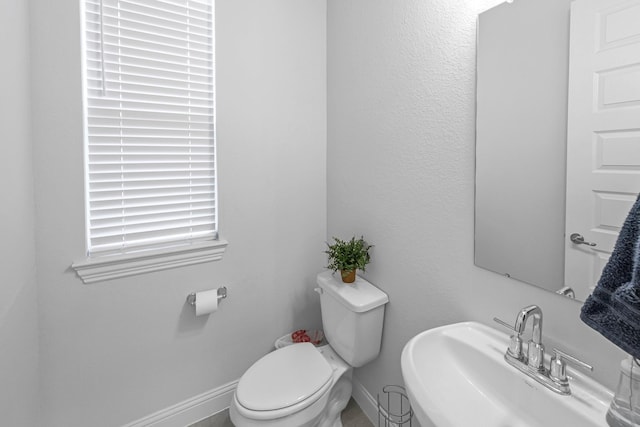 41015 Kimber Ln, Magnolia, TX 77354 - half bathroom featuring a sink, baseboards, and toilet