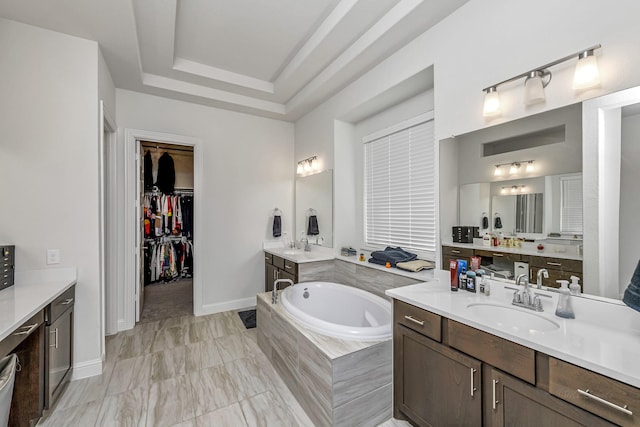 41015 Kimber Ln, Magnolia, TX 77354 - full bath featuring a walk in closet, a sink, baseboards, two vanities, and a garden tub