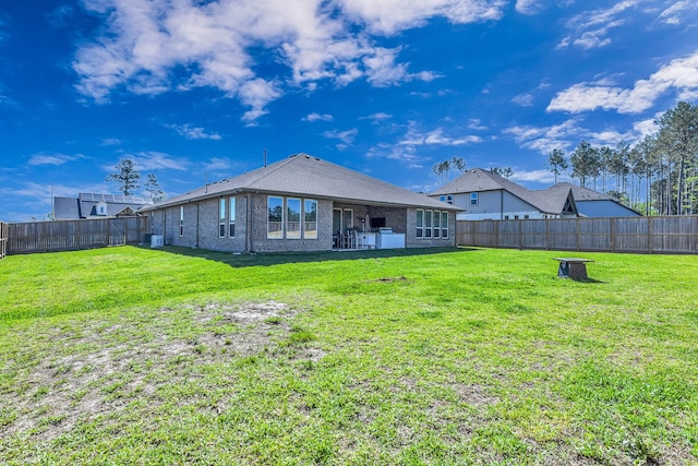 41015 Kimber Ln, Magnolia, TX 77354 - rear view of property with a fenced backyard, a yard, and brick siding