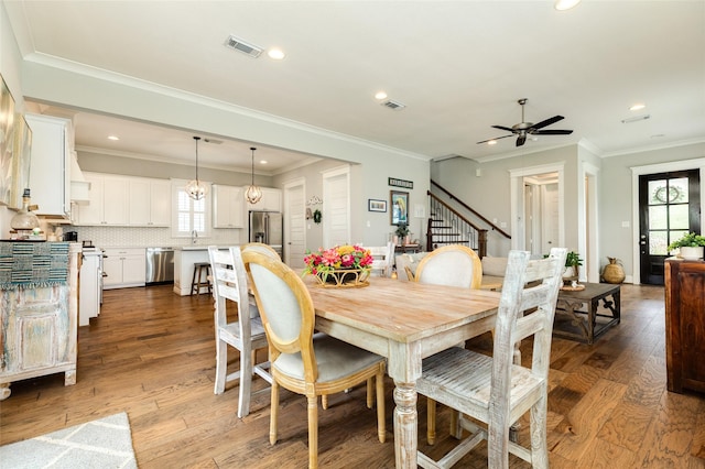 12 Caravelle Ct, Galveston, TX 77554 - dining room featuring healthy amount of natural light, ceiling fan, stairs, wood finished floors, and recessed lighting
