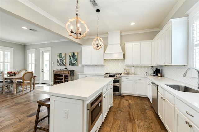 12 Caravelle Ct, Galveston, TX 77554 - kitchen with a sink, custom range hood, stainless steel appliances, a chandelier, and healthy amount of natural light